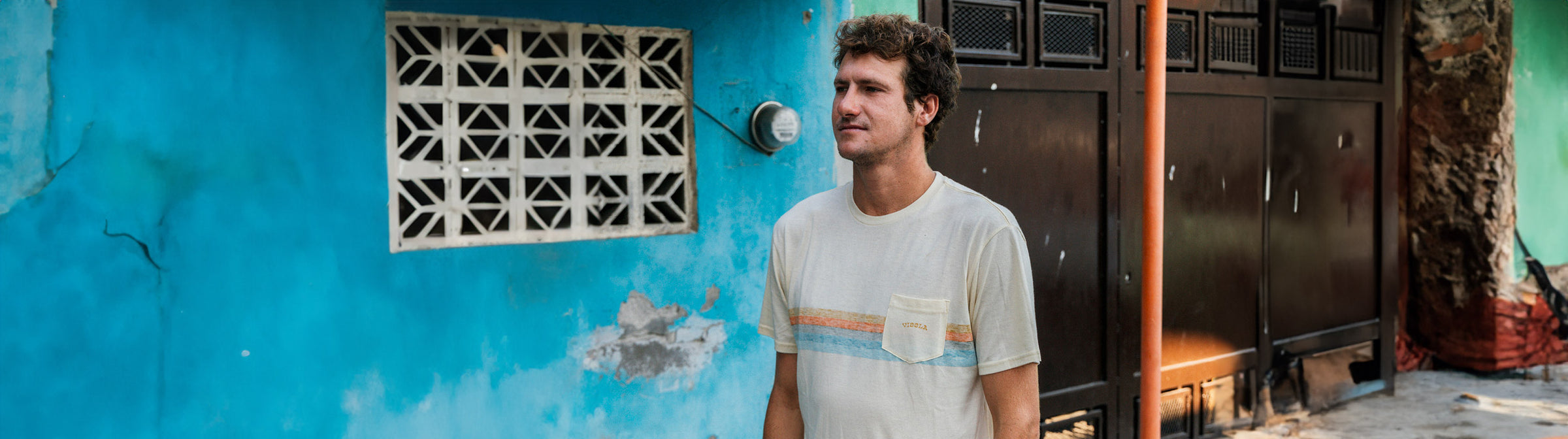 Andrew Jacobson walking through a village in Mexico wearing a Vissla knit pocket tee