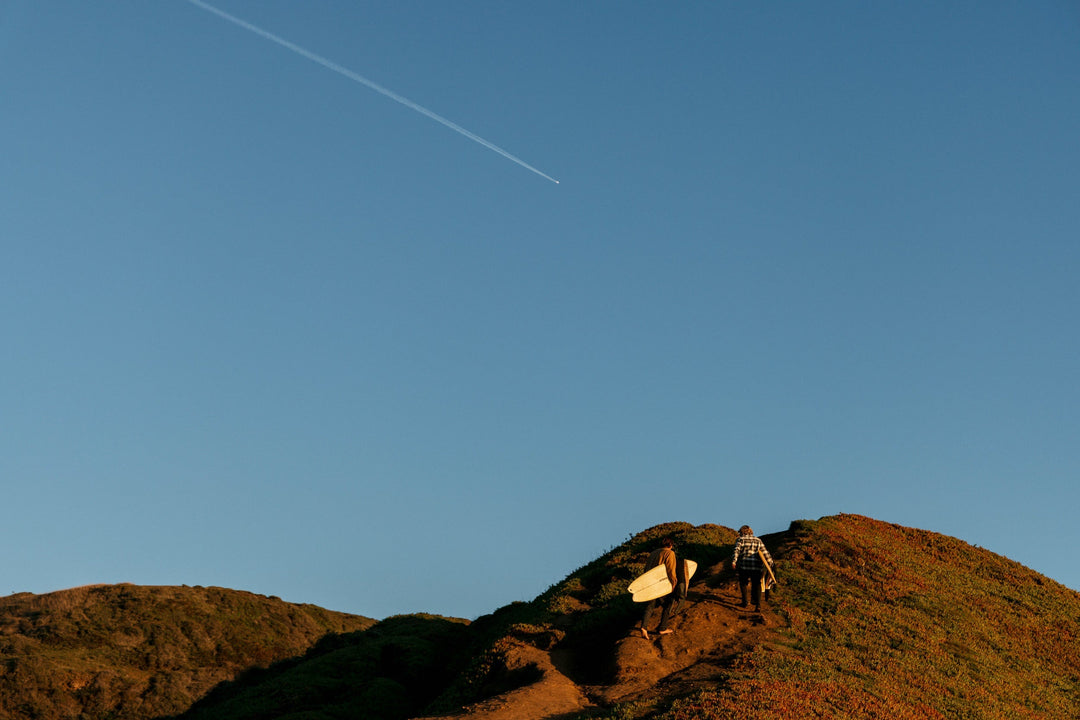 Nick Melanson & Derrick Disney hiking up a trail in search of waves in the new Vissla Fall Clothing Collection