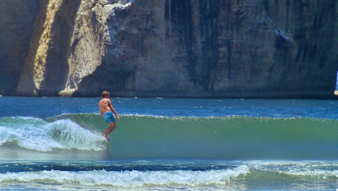 16mm screengrab from Thomas Campbell's film Yi-Wo, showing Nick Melanson noseriding a left hander